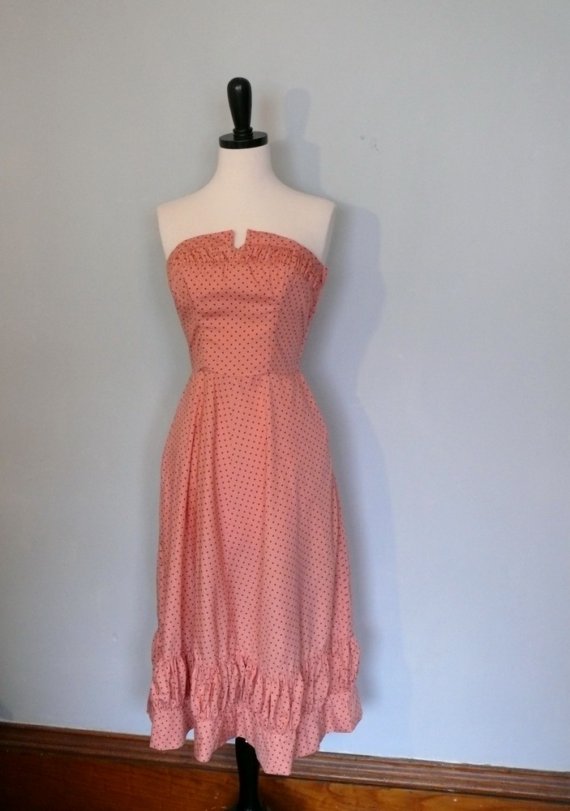 Strapless coral dress with a ruffled hem on a mannequin.